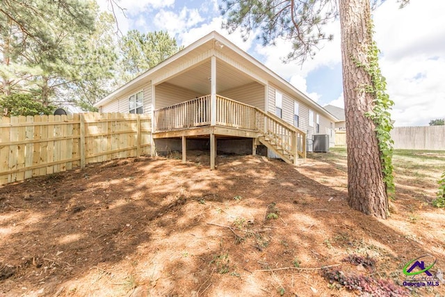 rear view of property featuring central AC unit and a wooden deck