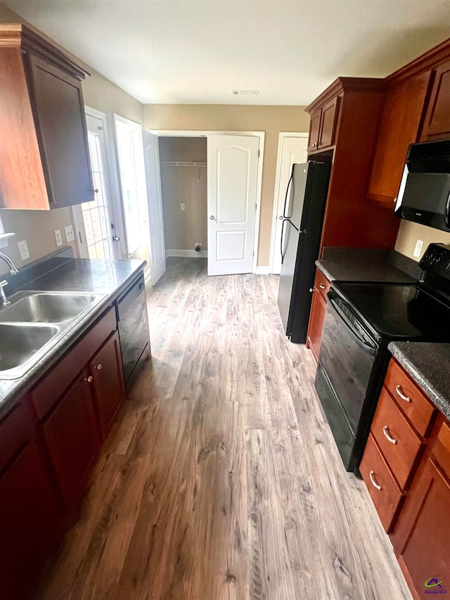 kitchen with wood-type flooring, sink, and black appliances