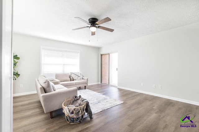 living room with hardwood / wood-style floors, a textured ceiling, and ceiling fan