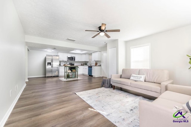 living room with ceiling fan and hardwood / wood-style floors