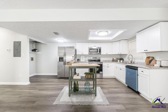 105 Westcliff Cir, Warner Robins, GA 31093 - kitchen featuring appliances with stainless steel finishes, baseboards, electric panel, white cabinets, and wood finished floors