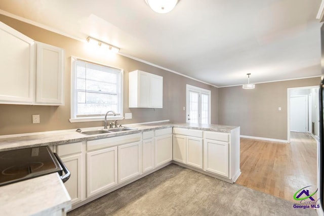 kitchen featuring white cabinets, decorative light fixtures, plenty of natural light, and sink