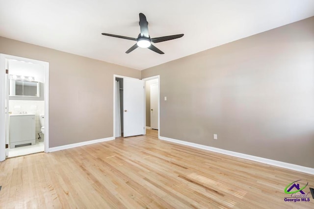 unfurnished bedroom featuring ceiling fan, light hardwood / wood-style floors, and connected bathroom