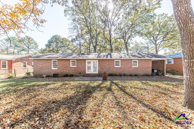 back of house with french doors and a yard