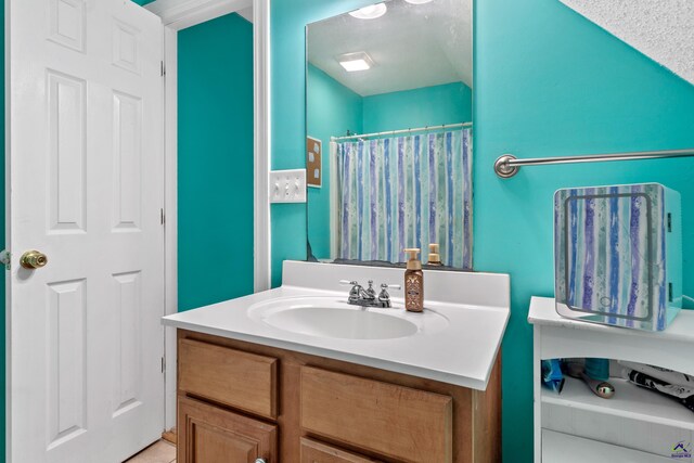 bathroom featuring vanity, a textured ceiling, and walk in shower