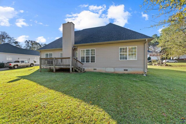 rear view of house featuring a lawn and a wooden deck