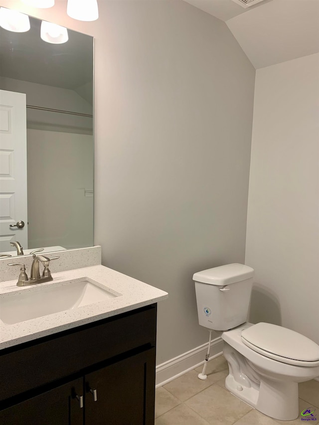 bathroom featuring tile patterned flooring, vanity, toilet, and lofted ceiling