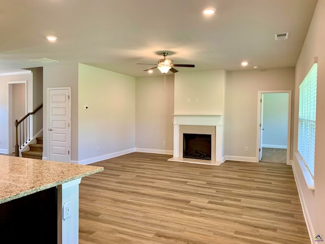 unfurnished living room featuring ceiling fan and light hardwood / wood-style flooring