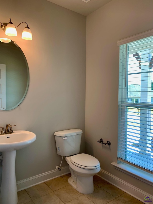 bathroom with tile patterned flooring, toilet, and a wealth of natural light