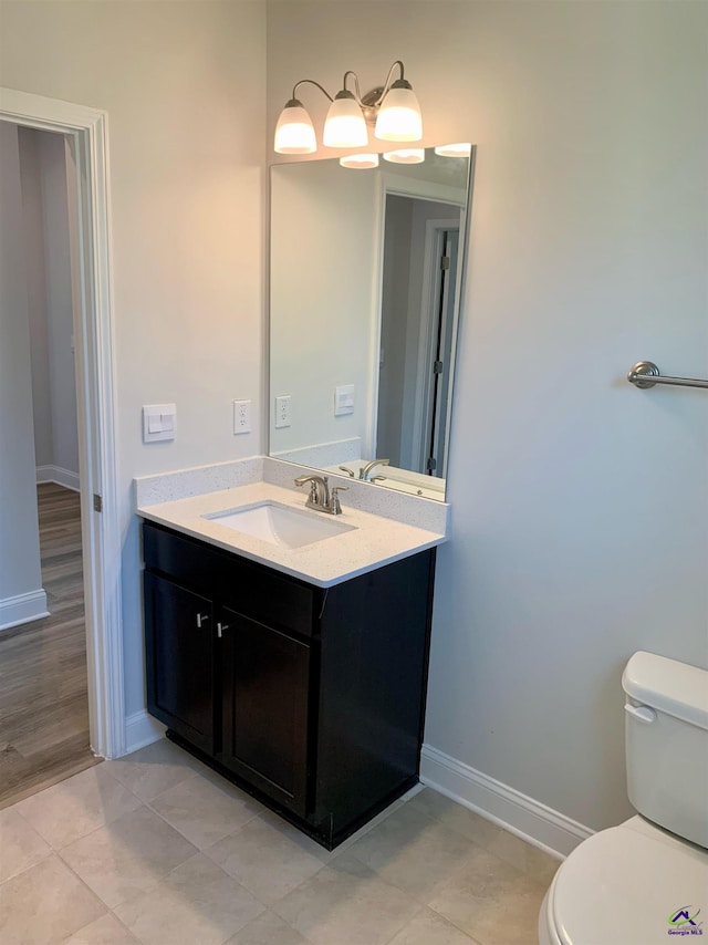 bathroom with hardwood / wood-style floors, vanity, and toilet