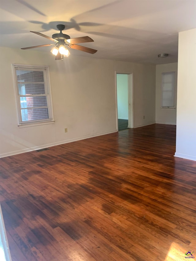 spare room featuring ceiling fan and dark wood-type flooring