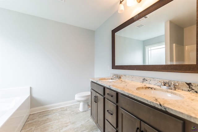 bathroom featuring vanity, toilet, and a tub to relax in