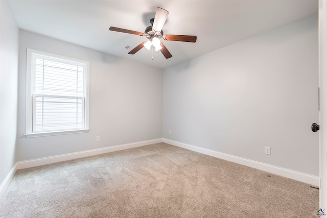 carpeted spare room featuring ceiling fan