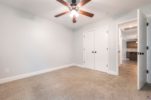 unfurnished bedroom featuring carpet flooring, ceiling fan, and a closet