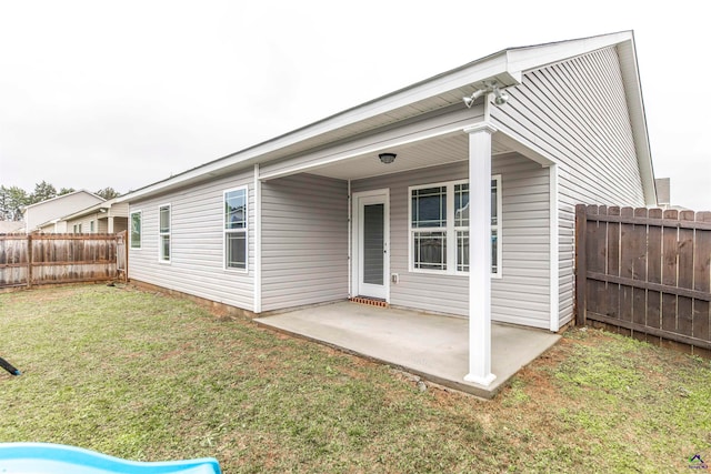 back of house with a yard and a patio