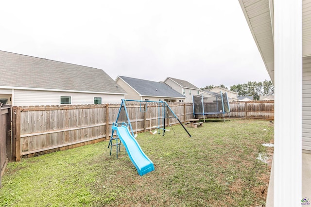 view of jungle gym featuring a trampoline and a lawn