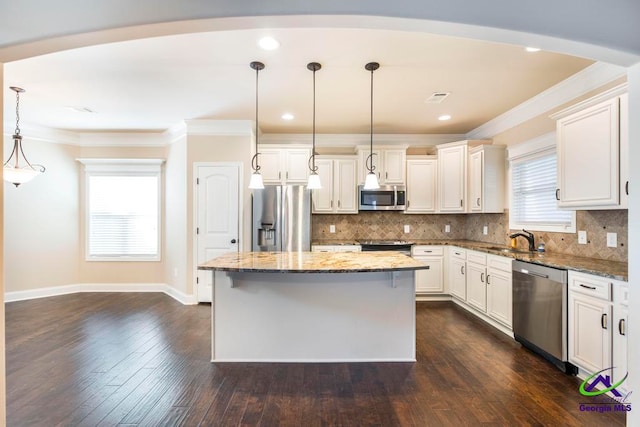 kitchen with a center island, stone countertops, decorative light fixtures, dark hardwood / wood-style flooring, and stainless steel appliances