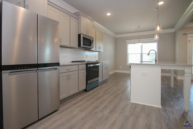 kitchen with a center island with sink, decorative light fixtures, crown molding, and stainless steel appliances