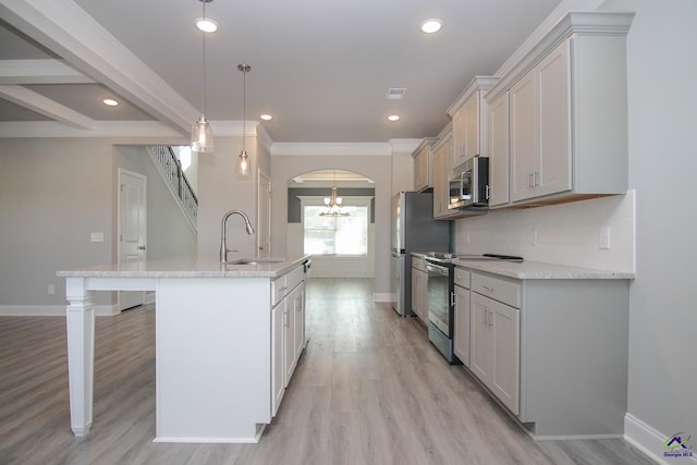 kitchen with light stone countertops, sink, hanging light fixtures, a center island with sink, and appliances with stainless steel finishes