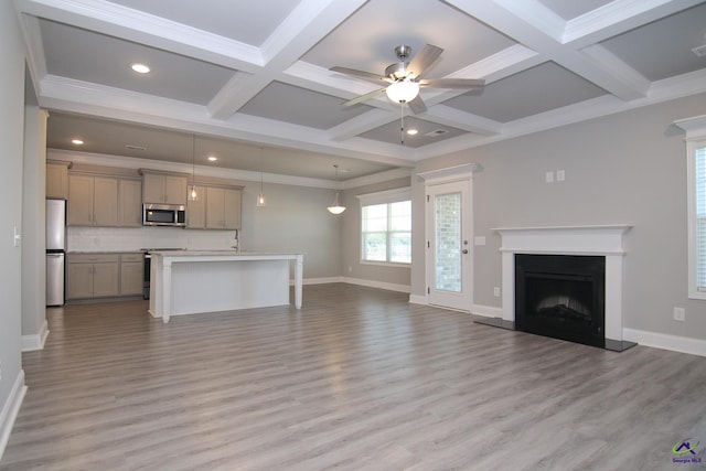 unfurnished living room featuring ornamental molding, light hardwood / wood-style floors, ceiling fan, and coffered ceiling