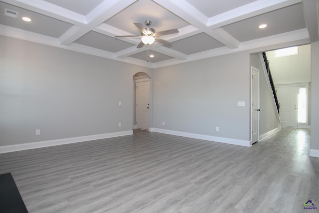 empty room featuring beam ceiling, coffered ceiling, and light wood-type flooring