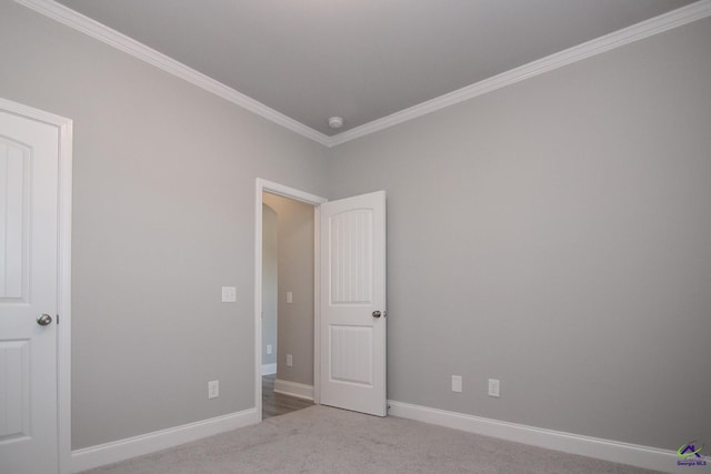 carpeted spare room featuring ornamental molding