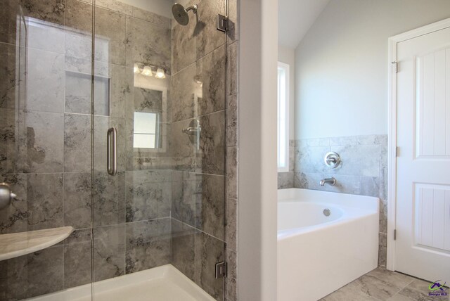 bathroom featuring lofted ceiling and plus walk in shower