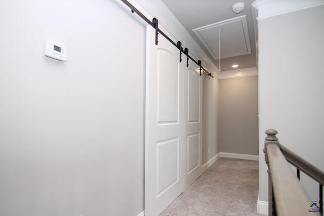 corridor with a barn door and light colored carpet