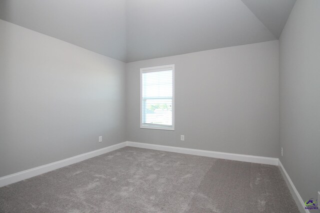 empty room with carpet flooring and vaulted ceiling