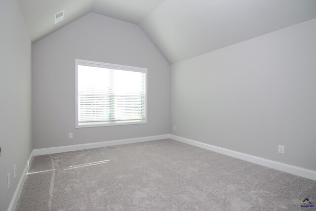 unfurnished room featuring lofted ceiling and carpet floors