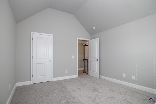 unfurnished bedroom with lofted ceiling and light carpet