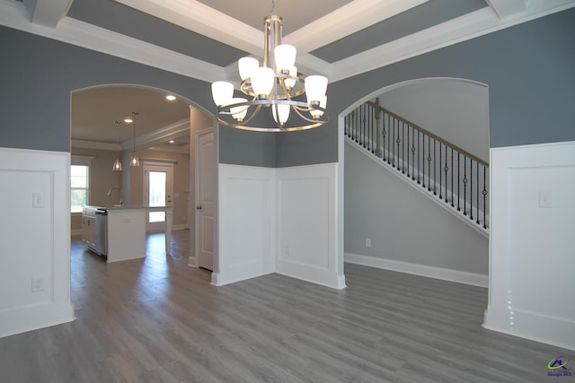 unfurnished dining area featuring sink, dark hardwood / wood-style flooring, crown molding, and a chandelier