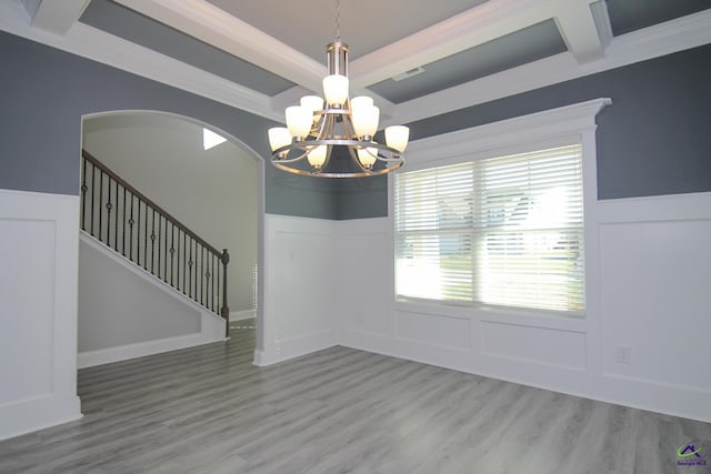 unfurnished dining area featuring beam ceiling, crown molding, hardwood / wood-style floors, and a notable chandelier