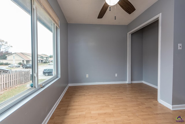 spare room featuring light hardwood / wood-style flooring, ceiling fan, and a healthy amount of sunlight