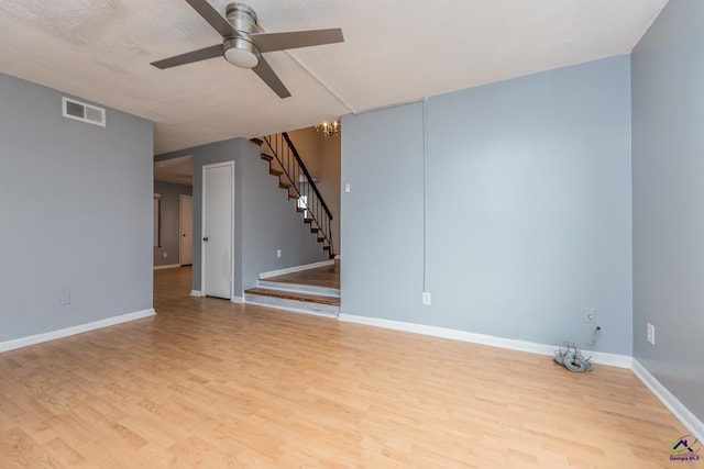 spare room featuring light hardwood / wood-style floors and ceiling fan with notable chandelier