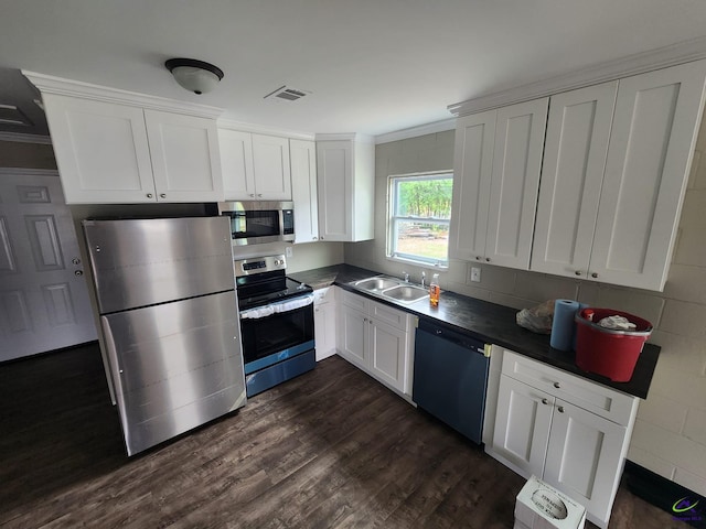 kitchen with sink, ornamental molding, appliances with stainless steel finishes, dark hardwood / wood-style flooring, and white cabinetry