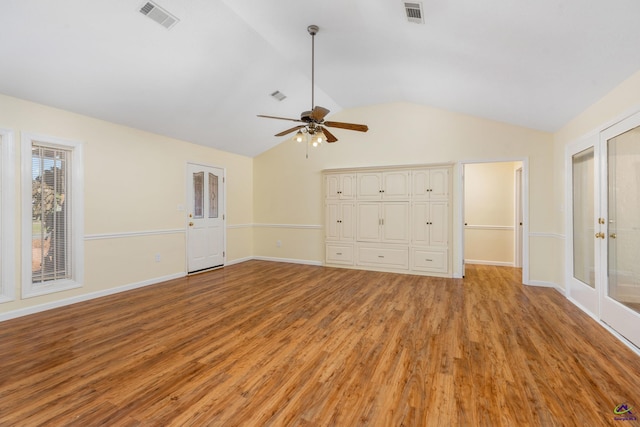 unfurnished living room featuring ceiling fan, light wood-type flooring, french doors, and vaulted ceiling