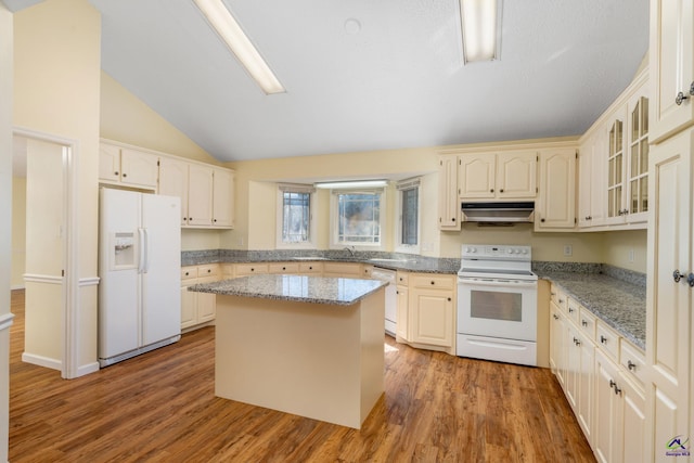 kitchen featuring light stone counters, a kitchen island, white appliances, and hardwood / wood-style flooring