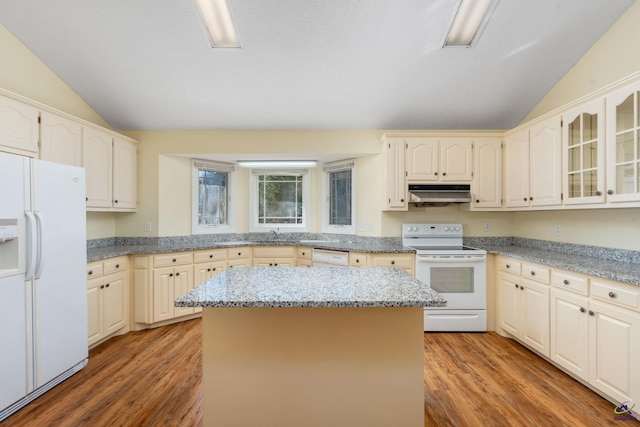 kitchen with wood-type flooring, white appliances, a center island, and vaulted ceiling