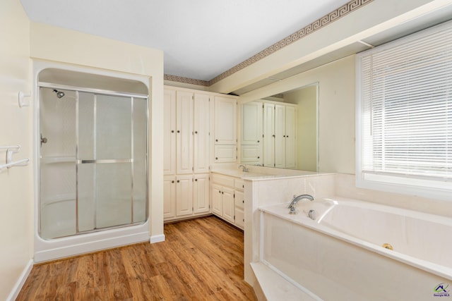 bathroom with hardwood / wood-style floors, vanity, and shower with separate bathtub