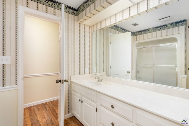 bathroom featuring hardwood / wood-style floors, vanity, and a shower with door