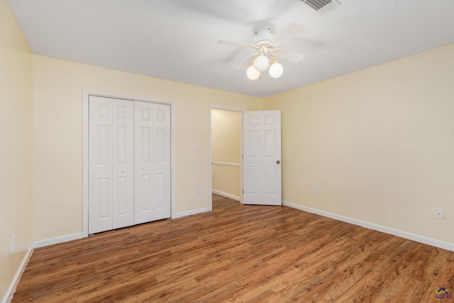 unfurnished bedroom featuring a closet, hardwood / wood-style flooring, and ceiling fan