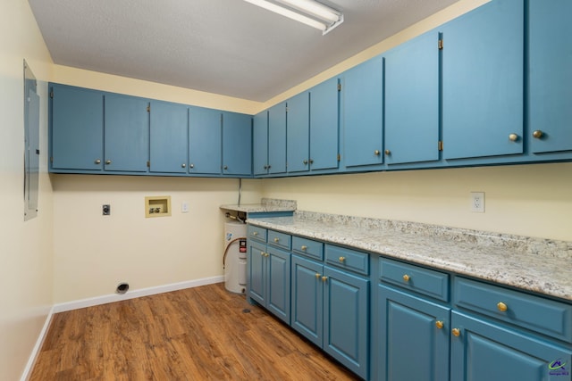 washroom featuring dark wood-type flooring, cabinets, electric dryer hookup, hookup for a washing machine, and a textured ceiling