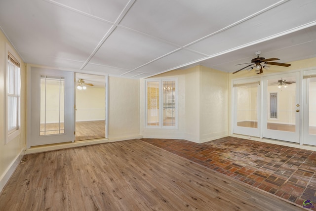 unfurnished sunroom with ceiling fan