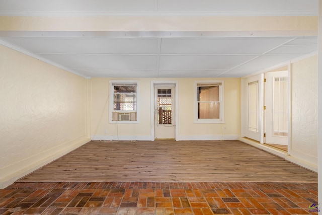 spare room featuring cooling unit, dark wood-type flooring, and ornamental molding