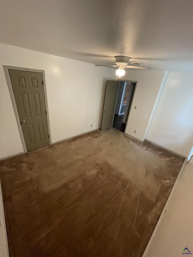 spare room featuring light carpet, baseboards, and a ceiling fan