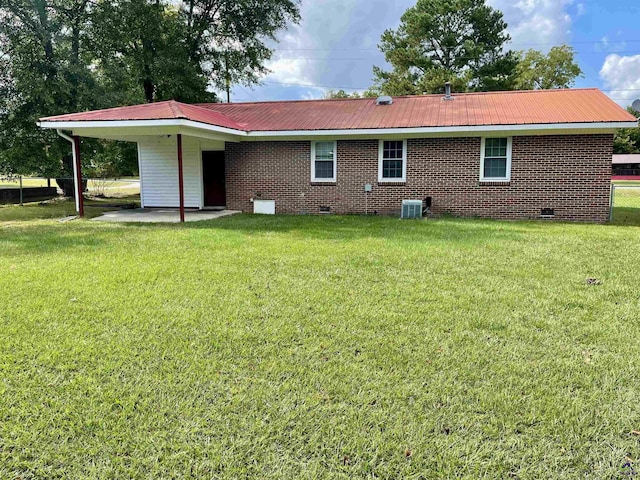 rear view of house featuring crawl space, a yard, and brick siding