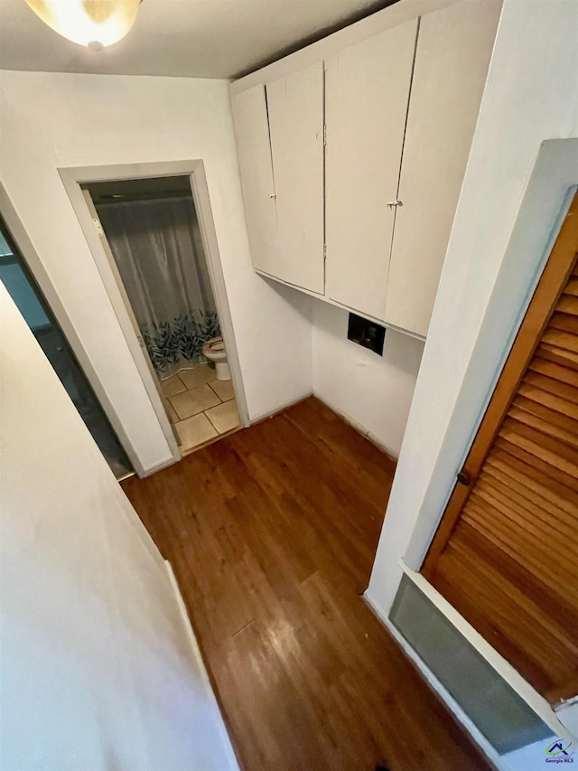 washroom with wood finished floors and cabinet space