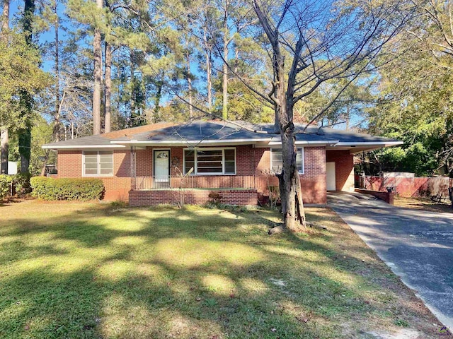 ranch-style house with a front lawn, a porch, and a carport