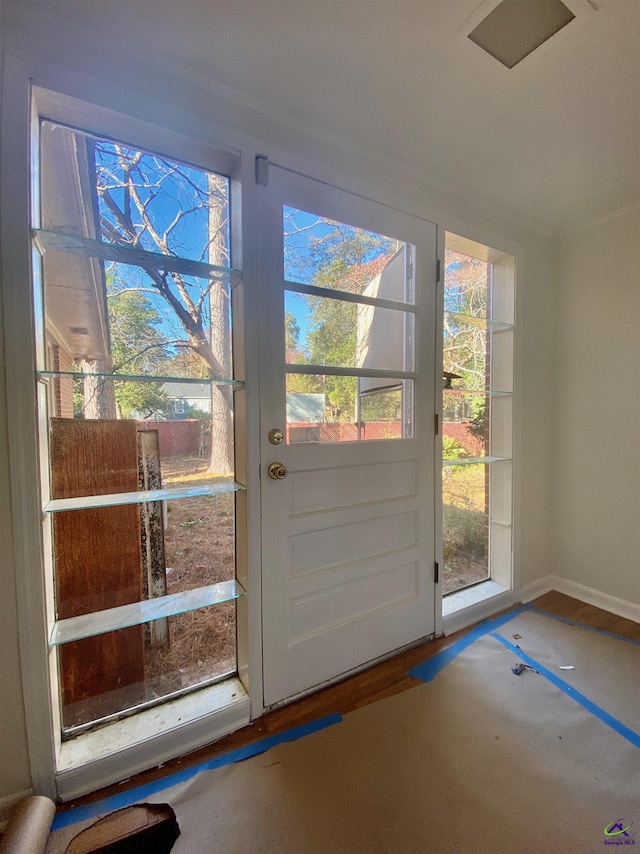 doorway with baseboards and wood finished floors